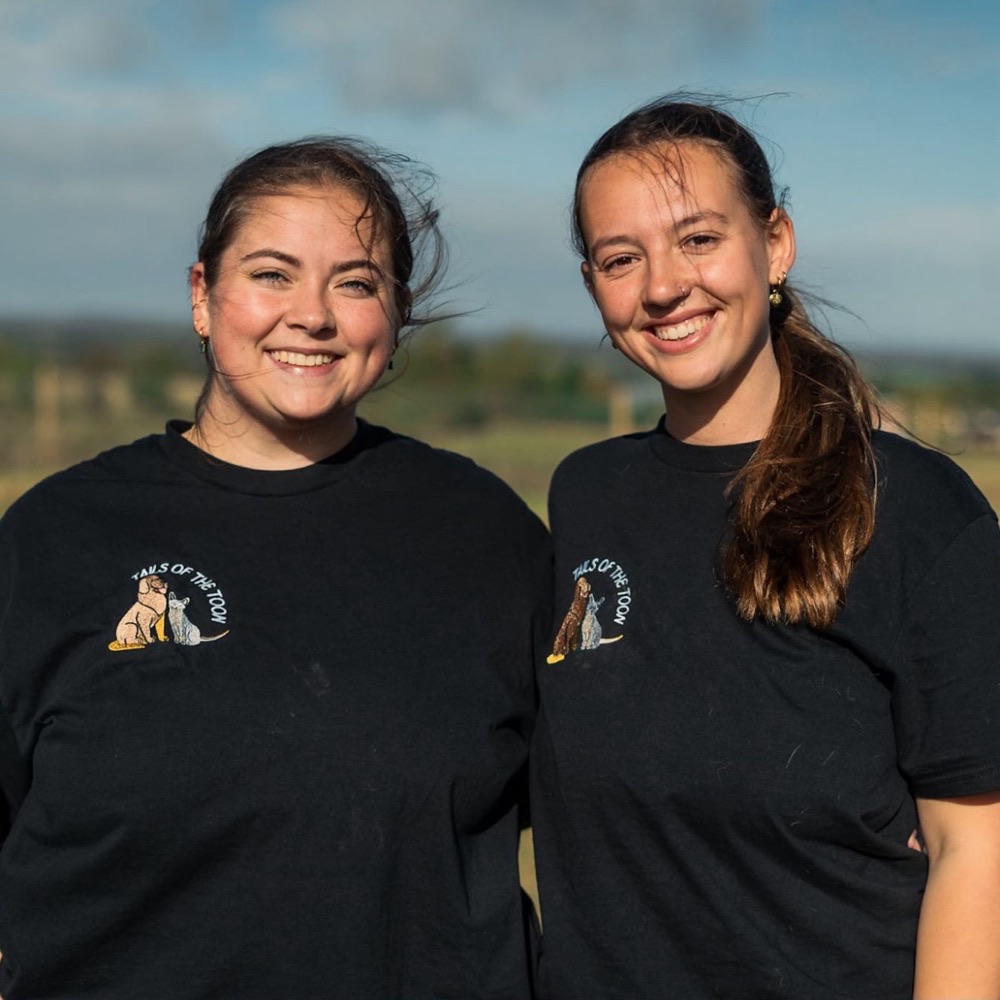 Sophie and Lily in their Tails of the Toon T-shirts, smiling in a field